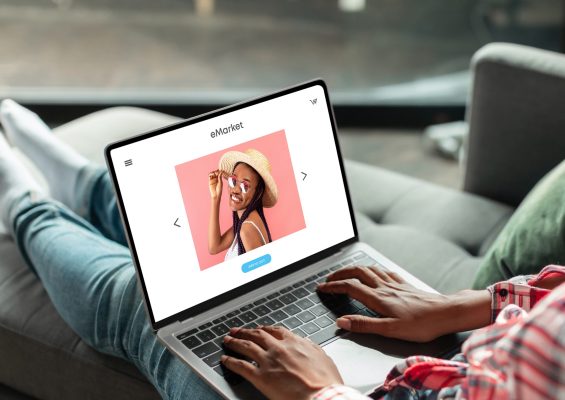 Black woman shopaholic enjoy online shopping, ordering new clothes at store on laptop screen, sitting on sofa at home. Website, app for fashion, order delivery, sale at home