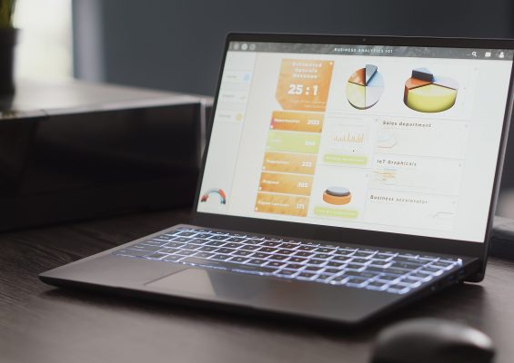 Empty desk filled with analytics papers and computer, workstation in corporation department room. Digital agency coworking space used for workers with creative occupation. Close up.